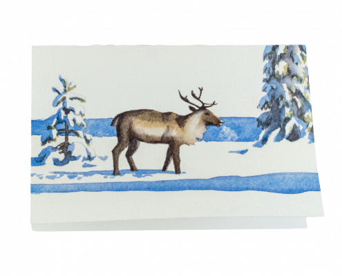 Carte de vœux peinte à la main représentant un renne marchant dans la neige au soleil et à côté d'épicéas couverts d'une épaisse couche de neige. L'ombre des arbres s'étend dans une couleur bleue vive et on voit la brume causée par le souffle du renne.